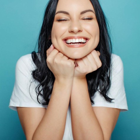 Smiling woman in white t-shirt, enjoying benefits of Homeoblock treatment