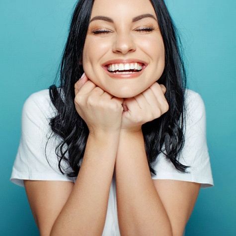 a woman smiling about her dental bridges in McKinney